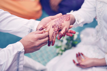 Malay Wedding Couple Putting A Gold Ring On Hand.Selective Focus