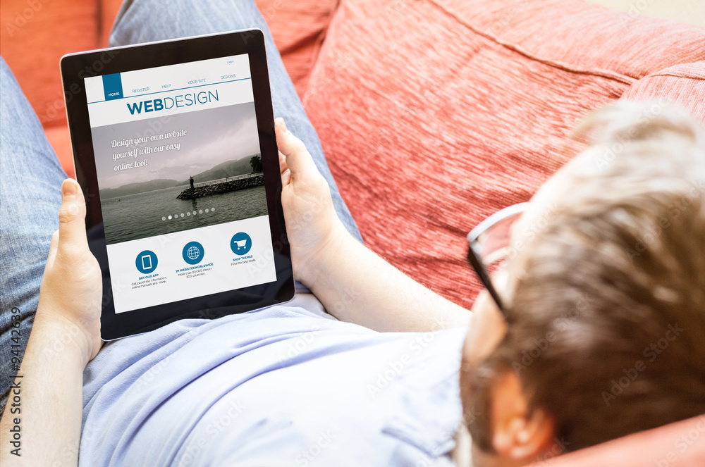 Poster hipster on the sofa with webdesign tablet
