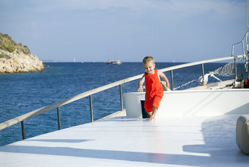 Fototapeta premium Lovely handsome boy running on a boat