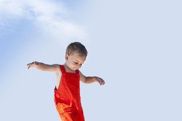 Lovely handsome boy is walking with his orange overall