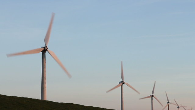 Row of windturbines with rotating blades.