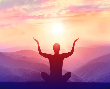 Silhouette of yoga man in the mountains at sunrise