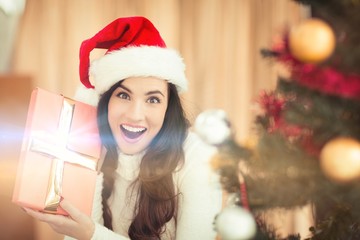 Surprised brunette holding a gift 