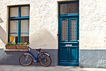 Fototapeta na wymiar Quaint home with blue door and blue window matching blue bicycle