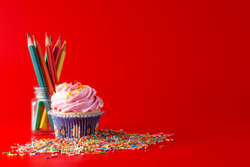 Colored cupcake on brigth red background