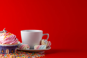 Fun children breakfast. Cupcake on brigth red background