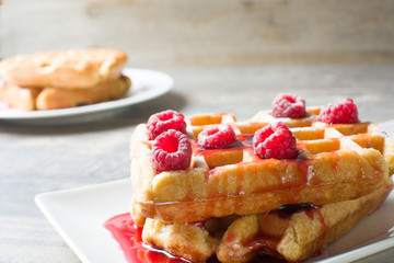 Waffles with raspberries and strawberry syrup