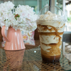 iced frappe coffee in plastic mug put on the rattan weave table