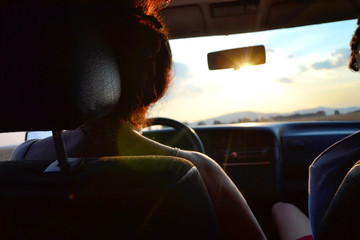 Fototapeta na wymiar Woman driving a car in the summer at sunset
