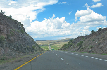 Road through landscape in Arizona, United States on a sunny and cloudy day in July.