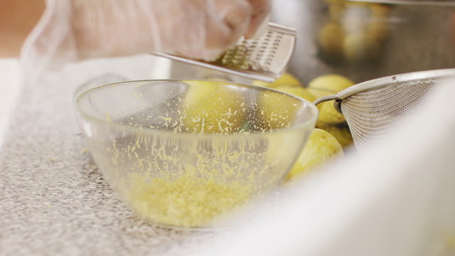 4K Lemon being put on a zester to extract the rind, in slow motion