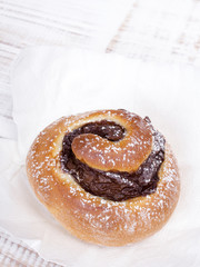 Sweet bun on white wooden background
