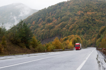 Fototapeta premium Red truck on the road in the mountains