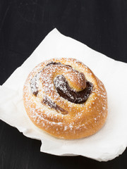 Sweet bun on black wooden background