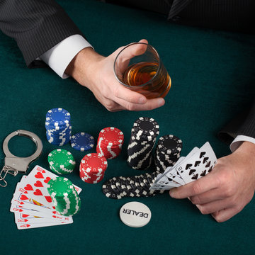 Gambler with alcohol and handcuffs