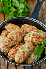 Minced meat kebab in a frying pan, top view