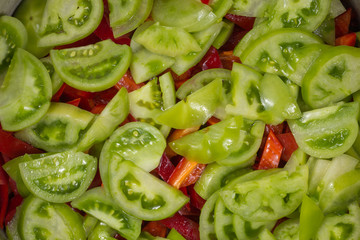 green tomatoes and red pepper in the background