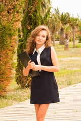 Naklejka premium beautiful teenager on campus with her folder of notes