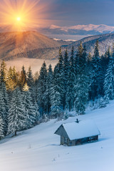 Colorful winter morning in the mountains at sunrise. View of the old farm.