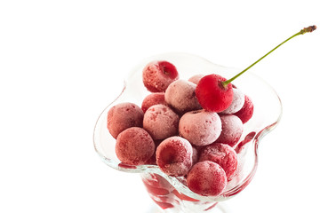 frozen cherries in the cup of glass on a white background