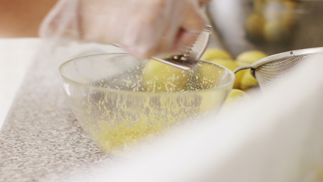 4K Lemon being put on a zester to extract the rind