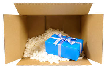Cardboard shipping delivery box top open opened with blue christmas or birthday gift inside and polystrene packing pieces isolated on white background opening present photo