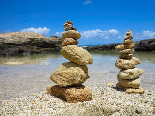 Piramide stack of zen stones near sea and blue sky