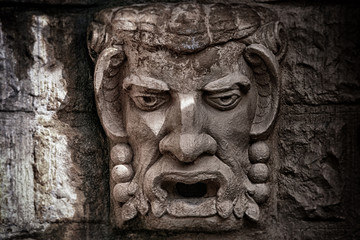 Fototapeta na wymiar Stone bas-relief a kind of a head of a demon