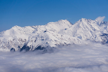 Fototapeta premium View on mountains and blue sky above clouds, Krasnaya Polyana