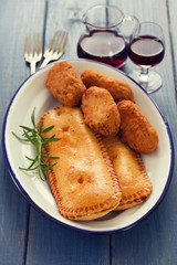 typical portuguese appetizers on white dish and red wine on blue wooden background
