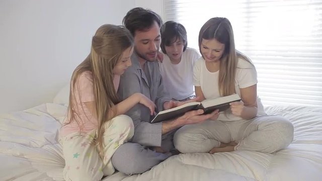 Family together reading a book