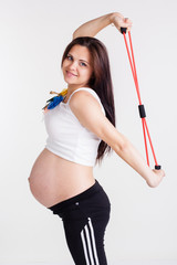 Pregnant woman doing sport with resistance band