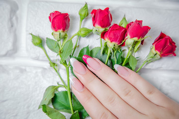 Stylish manicure on a background of flowers, beauty salon
