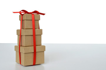 Three gift boxes tied together with red ribbon on light background