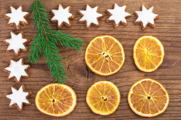 Fototapeta na wymiar Christmas cookies and orange slices over wooden background