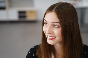 frau im büro schaut lächelnd zur seite