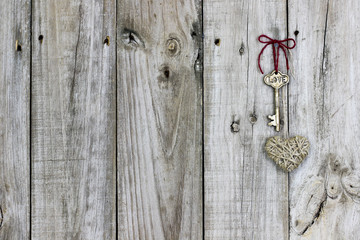 Skeleton key and rope heart hanging on rustic wood door