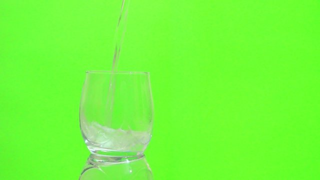 yeşil zemin üzerinde su bardağını dolduruyor