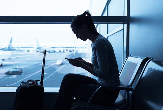 Woman Using Mobile Smart Phone At The Airport