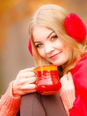 Girl in autumn park enjoying hot drink