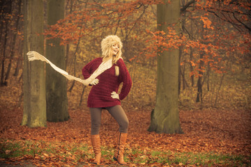 Fashion woman in windy fall autumn park forest.