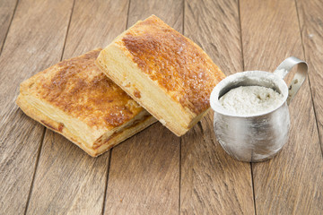 Pastel relleno de queso en mesa rústica.