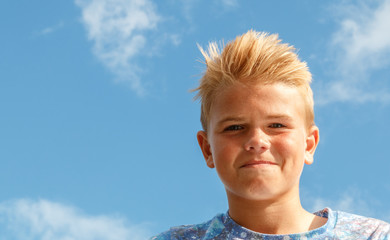 Blonde teenage boy  with spiky hair smirking or smiling
