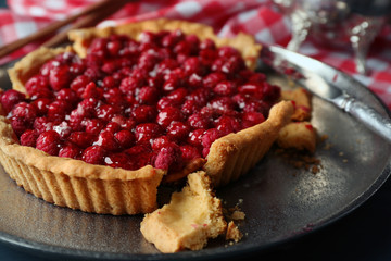 Tart with raspberries on tray, on wooden background