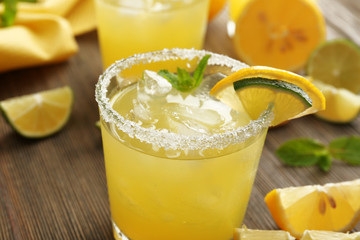 Glasses of lemon juice on wooden table, closeup