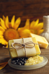 Naklejka premium Soap bar and Spa treatments and sunflower on wooden background