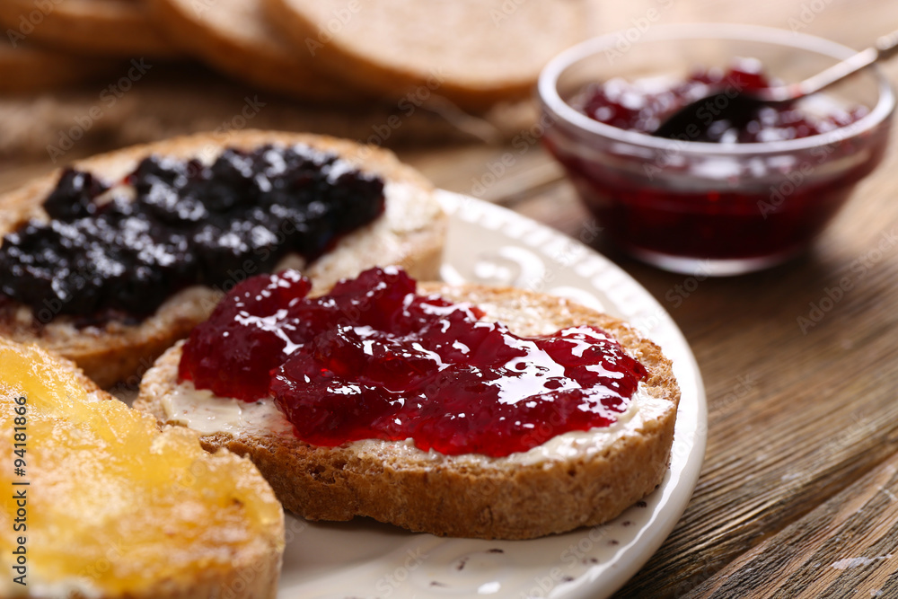 Poster fresh toast with butter and different jams on table close up