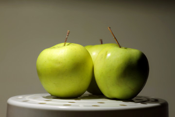 Fresh green apples on white plate studio isolated