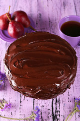sweet chocolate dessert with pear and cup of tea on wooden background