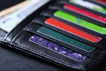 Black leather wallet with credit cards and money, close up